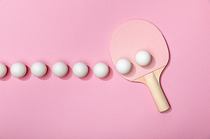 flat lay with white table tennis balls and racket on pink background