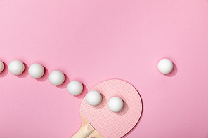flat lay with white plastic table tennis balls and racket on pink background