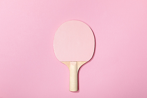 top view of table tennis pink wooden racket on pink background