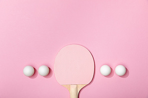 flat lay with white table tennis balls and wooden racket on pink background