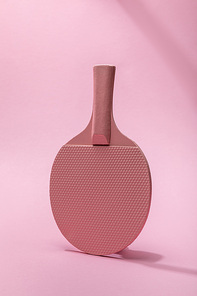 table tennis racket on pink background with copy space