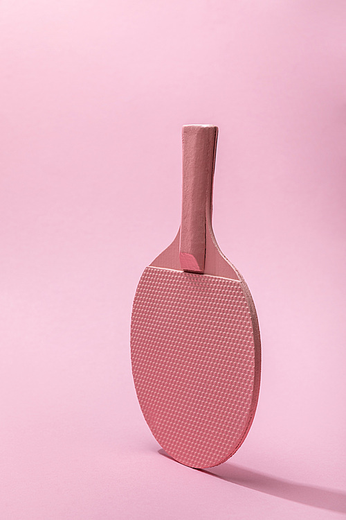 ping-pong racket on pink background with copy space