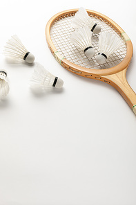 close up view of wooden badminton racket and shuttlecocks on white background with copy space