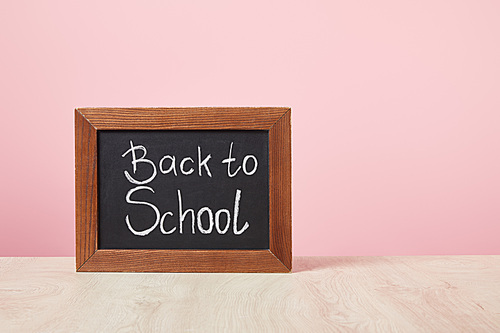 chalkboard with back to school lettering isolated on pink