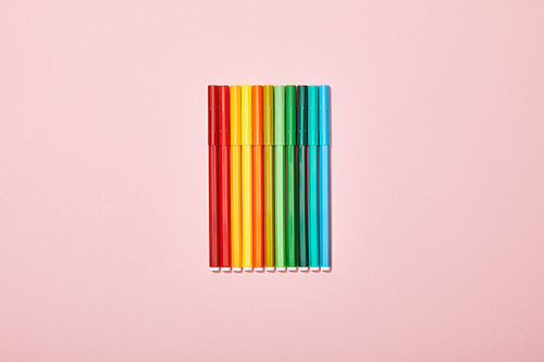 top view of multicolored felt pens isolated on pink
