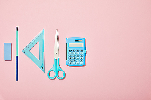 flat lay with blue school supplies isolated on pink with copy space