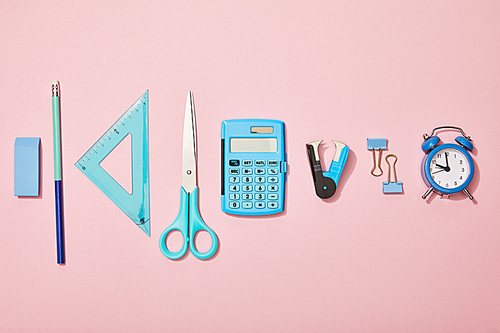 flat lay with blue school supplies isolated on pink
