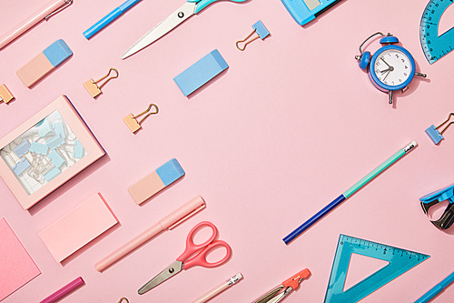 flat lay with blue school supplies and copy space isolated on pink