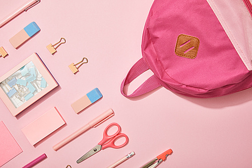 flat lay with pink school supplies and backpack isolated on pink