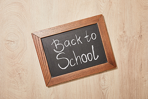 top view of chalkboard with back to school lettering on wooden desk