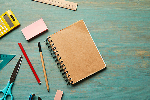 top view of empty notebook near school supplies at wooden table