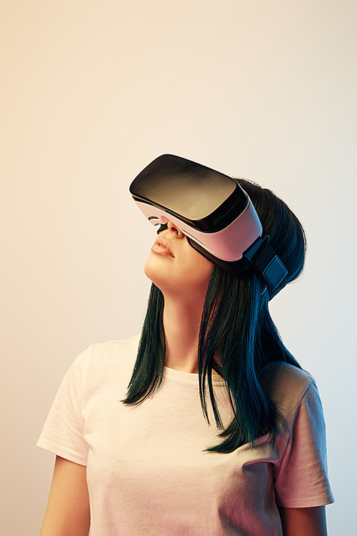 brunette woman wearing virtual reality headset on beige and blue