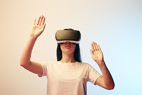 brunette woman in virtual reality headset gesturing on beige and blue