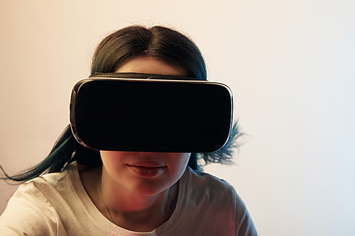 brunette girl wearing virtual reality headset and  on beige