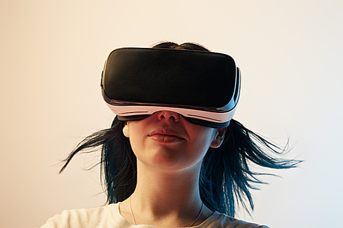 brunette girl wearing virtual reality headset on beige