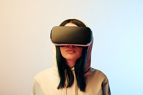 attractive brunette woman in virtual reality headset on beige and blue