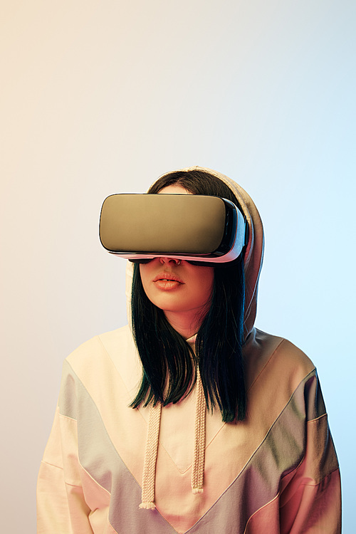beautiful brunette woman in virtual reality headset on beige and blue