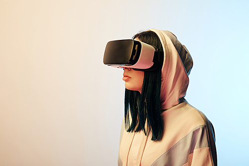 beautiful brunette young woman in virtual reality headset on beige and blue