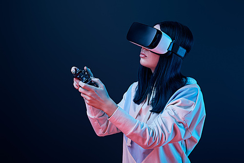 KYIV, UKRAINE - APRIL 5, 2019: Brunette woman holding joystick while playing video game in virtual reality headset on blue