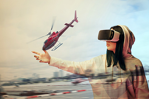 double exposure of brunette girl gesturing while using virtual reality headset and helicopter flying near buildings