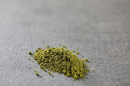 selective focus of green matcha powder on table