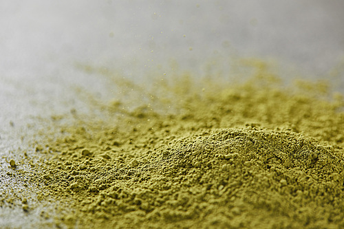 selective focus of green matcha powder on table