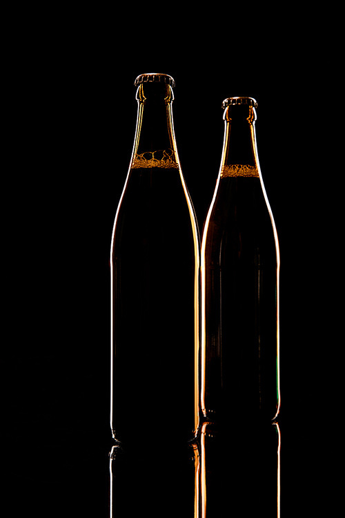 glass of beer on wooden table isolated on black