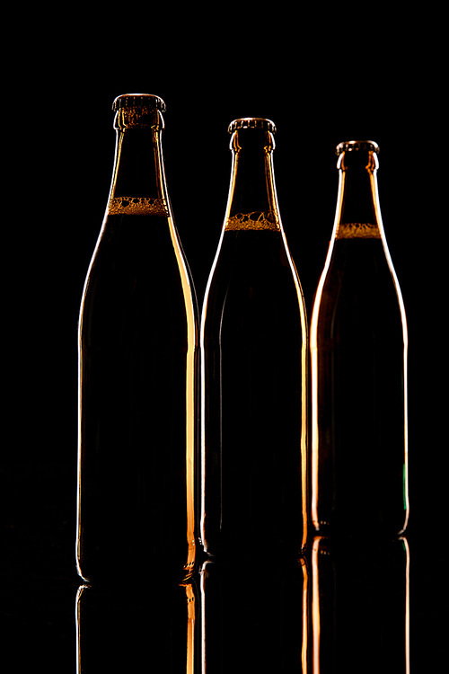 glass of beer on wooden table isolated on black