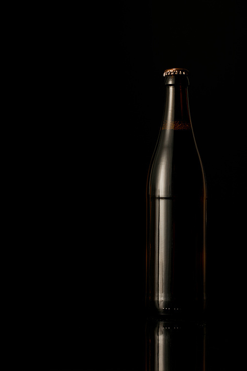dark glass bottle of beer isolated on black