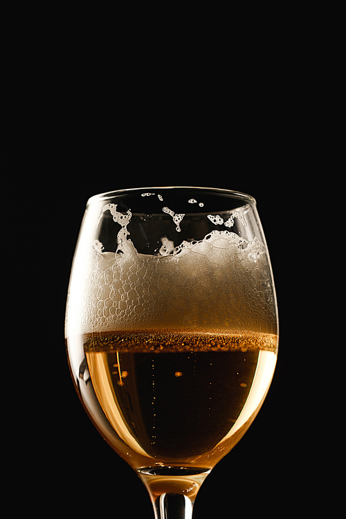 glass of beer with white foam isolated on black