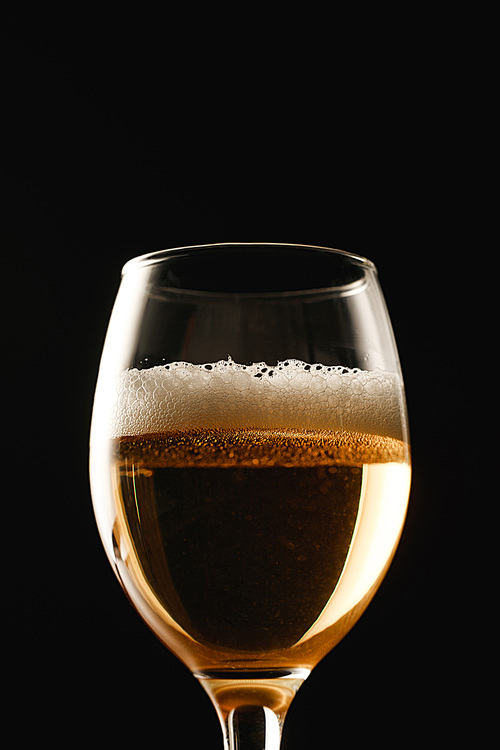 glass of beer with foam isolated on black