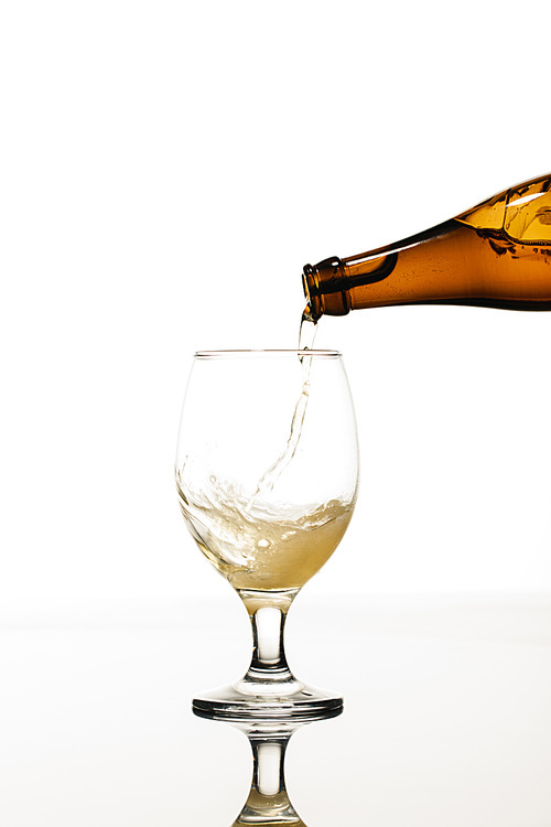 beer pouring from bottle into glass isolated on white