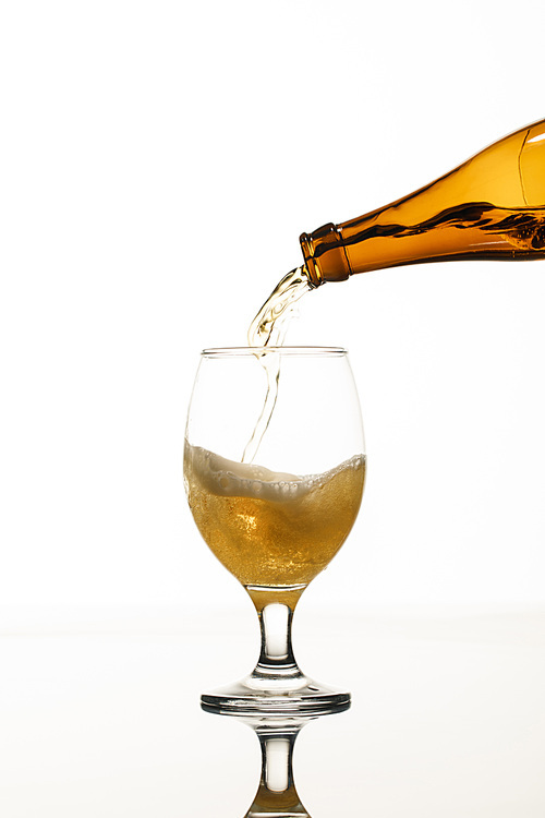 beer pouring from bottle into glass isolated on white