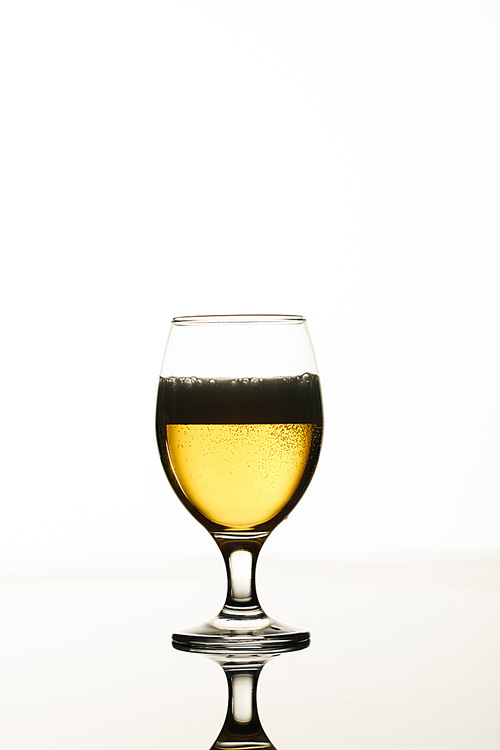 glass of beer with foam and back light isolated on white