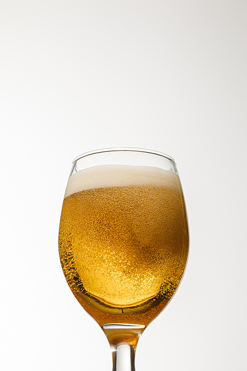 low angle view of glass of beer with foam isolated on white