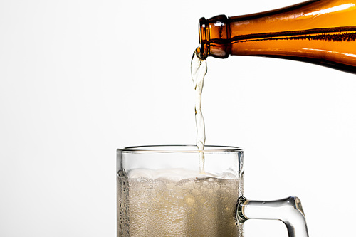 beer pouring from bottle into glass with white foam isolated on white