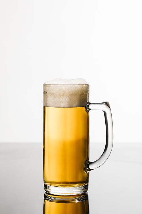 glass of beer with foam isolated on white