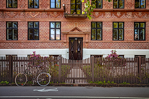 front view of parked bicycle near wooden fence in front of building in Copenhagen, Denmark