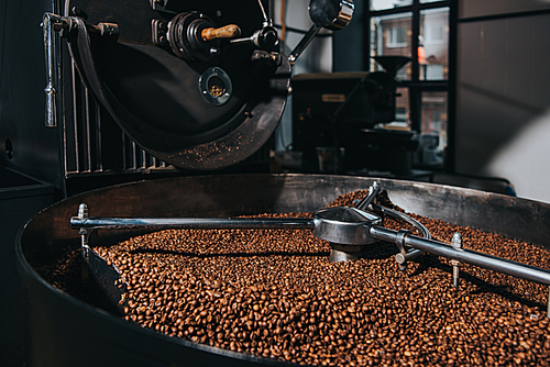 Interior of coffee production workshop with working coffee roasting machine