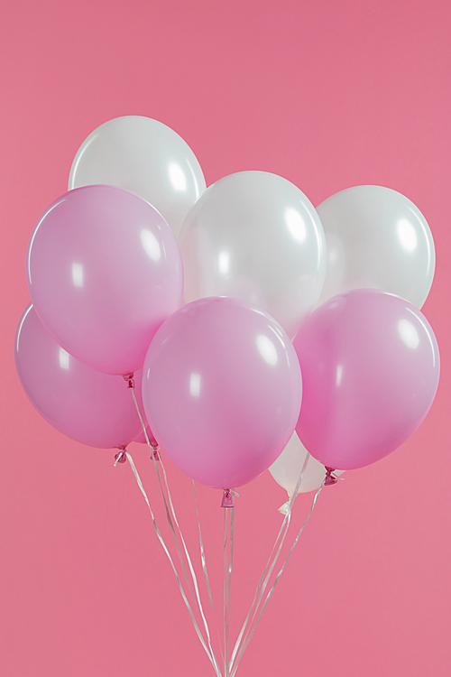 Decorative white and pink balloons isolated on pink