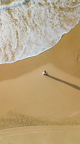 aerial view of young woman standing on sandy beach in front of wavy sea, Ashdod, Israel