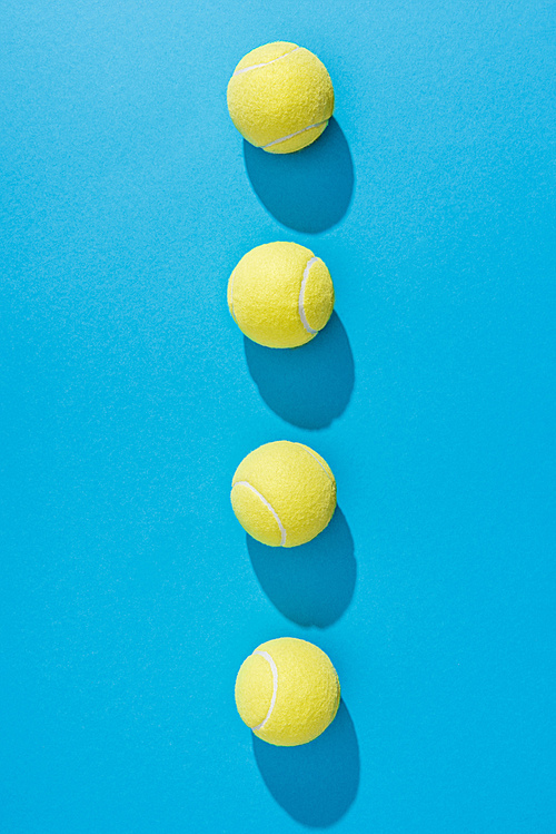 top view of arranged tennis balls on blue background