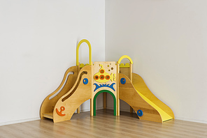 beautiful bright wooden slides in playing room at kindergarten