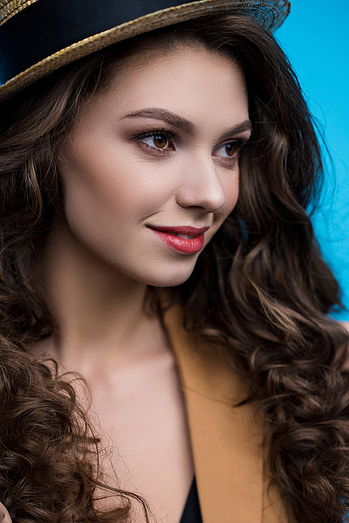 close-up portrait of sensual young woman with long curly hair in canotier hat