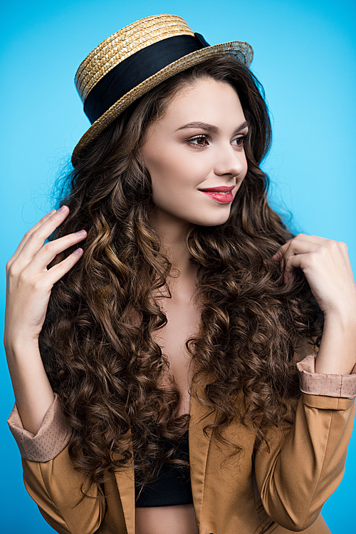 attractive young woman with long curly hair in canotier hat and jacket