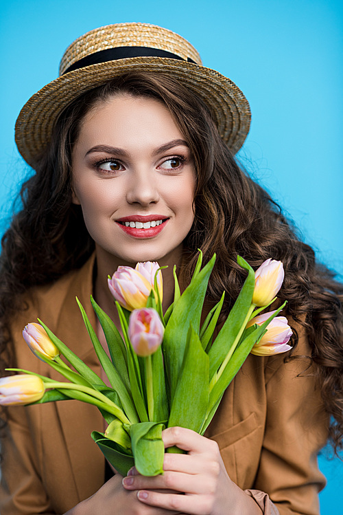 happy young woman in canotier hat and jacket holding bouquet of beautiful tulips