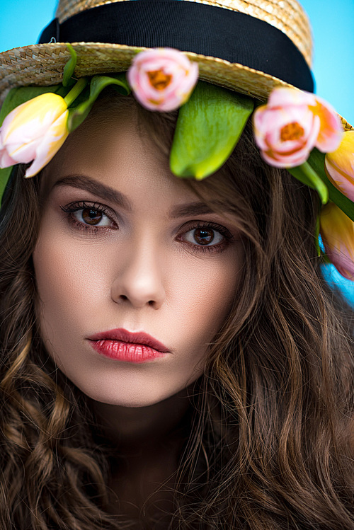 attractive young woman in canotier hat with beautiful tulips under it