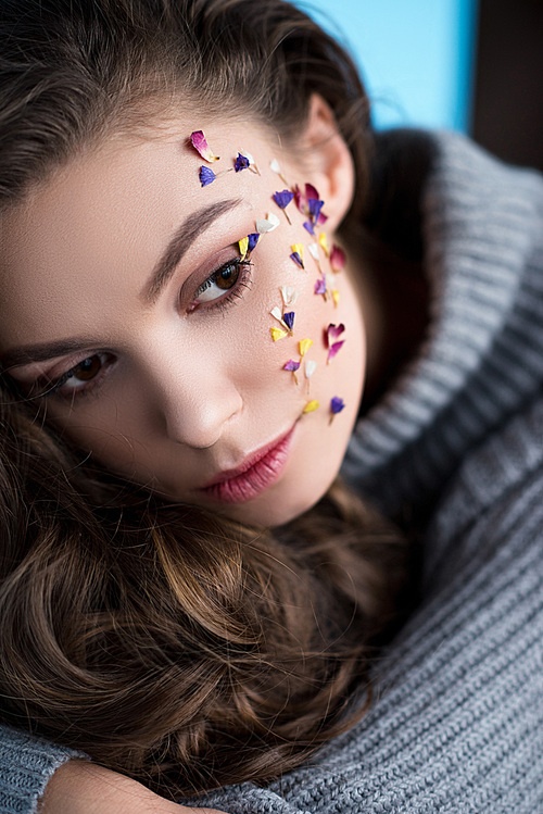 close-up portrait of woman with flowers on face in warm sweater