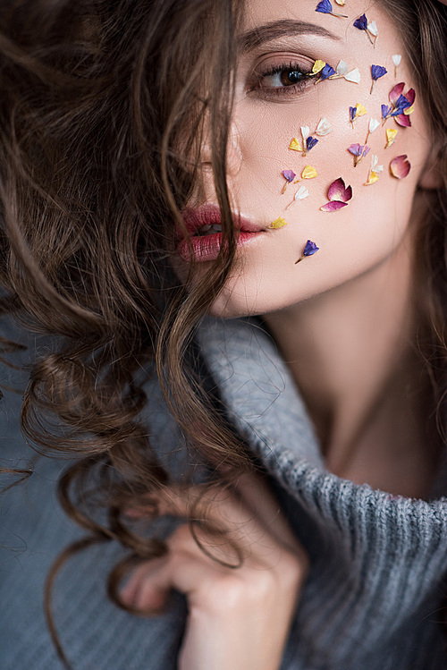 selective focus of sensual brunette woman with flowers on face 