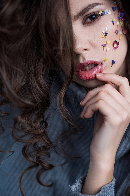 close-up view of beautiful brunette woman with flowers on face 